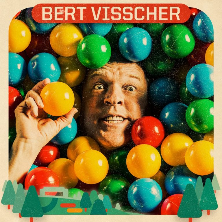 Een man met een blijde uitdrukking houdt een gekleurde bal vast, omgeven door een zee van kleurrijke ballen.