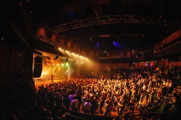Uitgelaten publiek in kleine zaal bij een concert