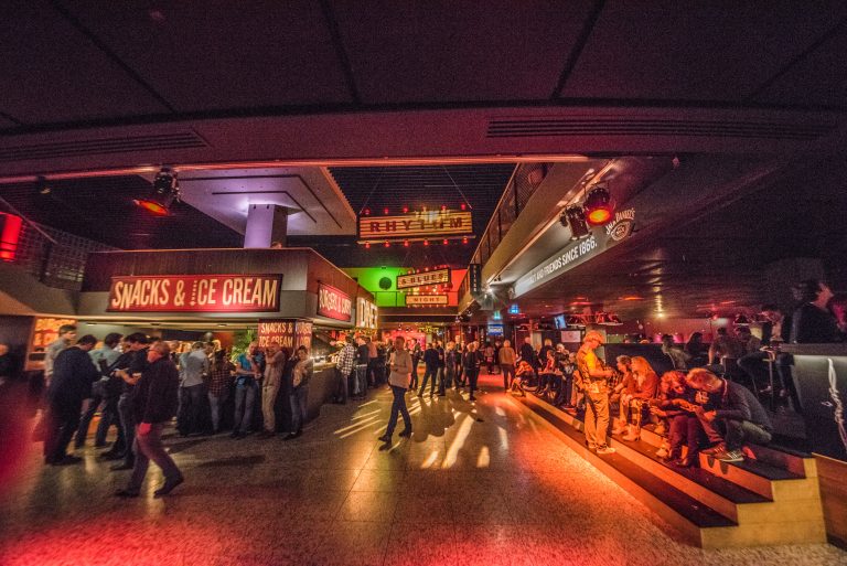 Drukke bar met sfeervolle verlichting en gasten die socializen.