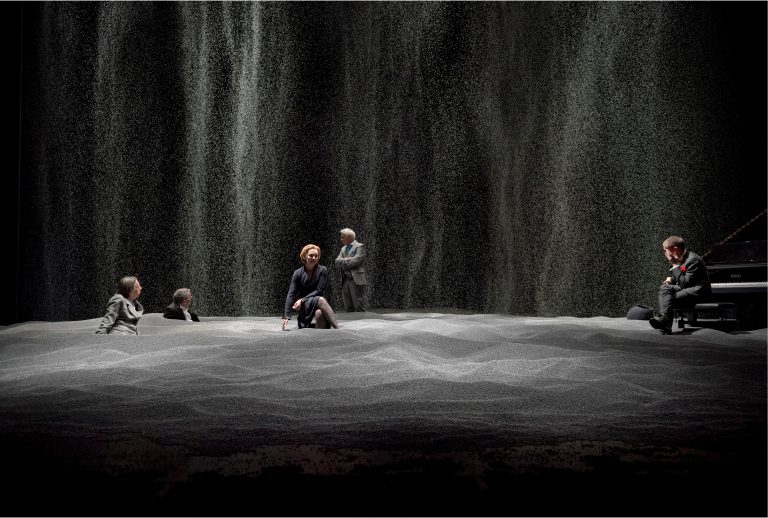Een groep mensen zit bij een waterval in een natuurlijke, rustige omgeving.