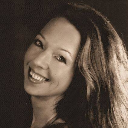 Zwart-wit foto van een vrouw met een glimlach en lang, golvend haar.