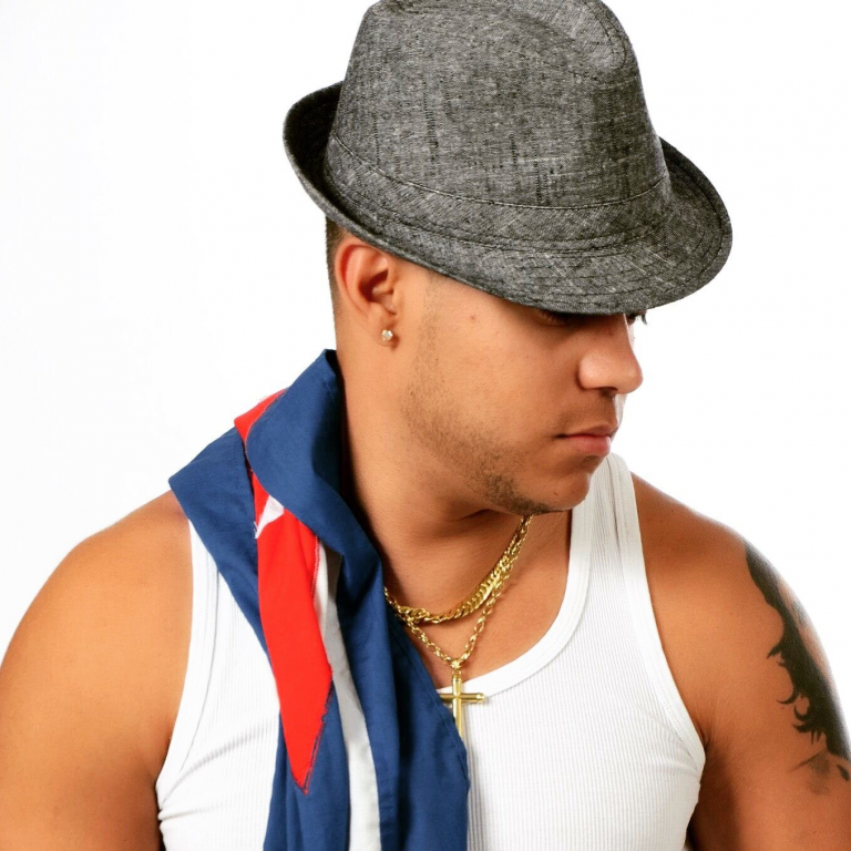 Man met een grijze hoed, een witte tanktop en een sjaal met rode en blauwe kleuren.