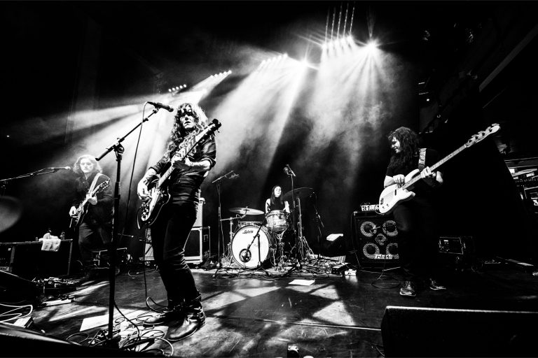 Een liveband optredend op een podium met fel licht en een energieke sfeer.