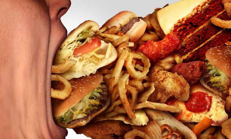 Een open mond gevuld met een overvloed aan fastfood, zoals hamburgers, frietjes en gefrituurde kip.
