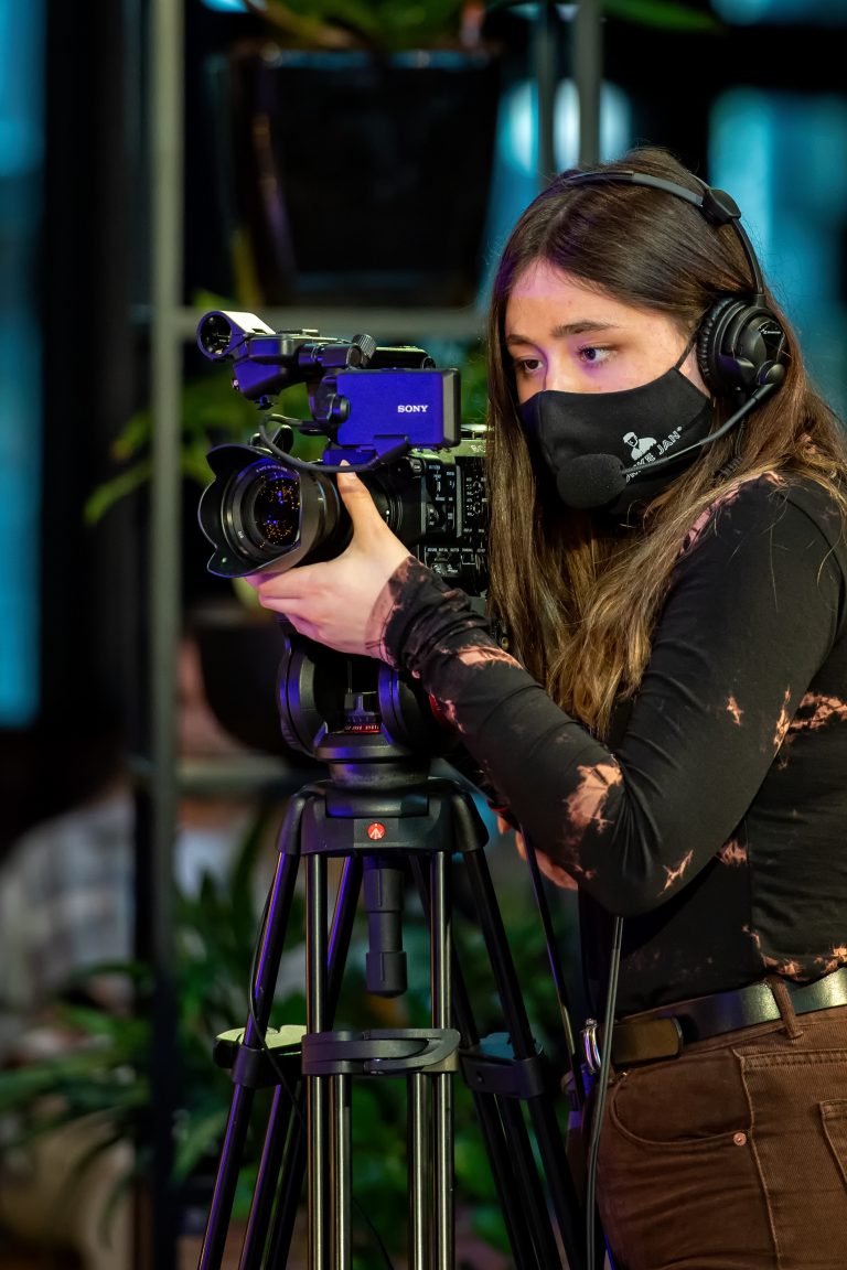 Cameravrouw die opnames maakt tijdens streaming lab.