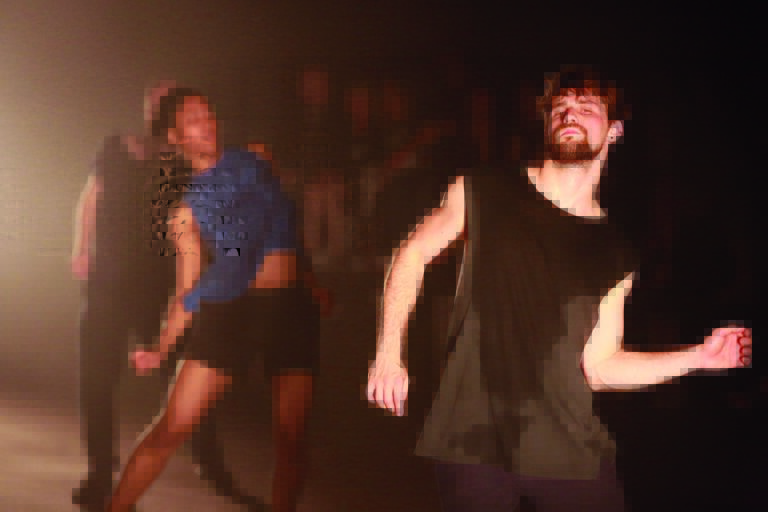 Een danser in een zwart shirt die energiek beweegt op een podium.