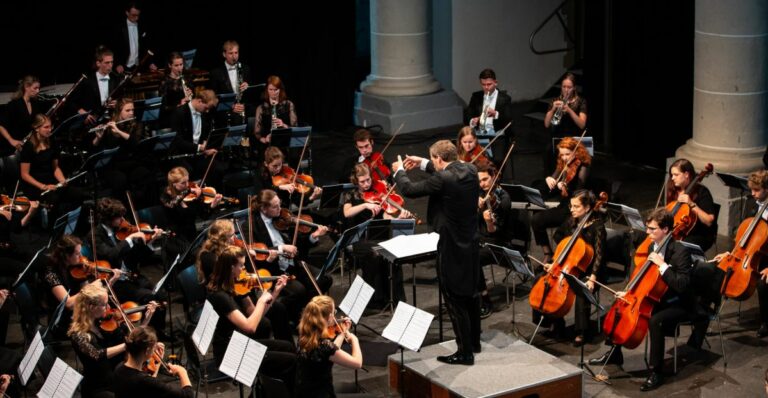 Een dirigent leidt een orkest van muzikanten tijdens een live-uitvoering.