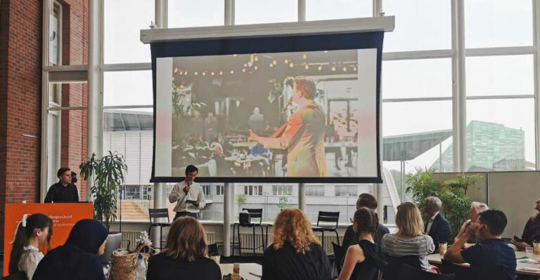 Presentatie open podium op groot scherm met publiek