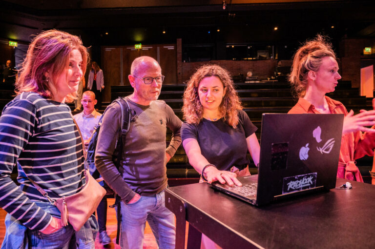 Deelnemers achter laptop bij New Technology - 'The live-event of 2050’