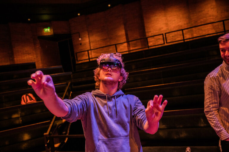 Deelnemer met VR Bril in kleine zaal.