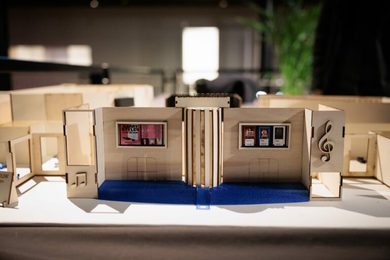 Een maquette van een kamer met twee muren en ramen, gepresenteerd in een binnenruimte.