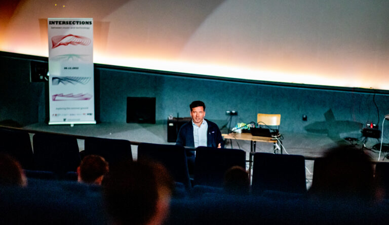 Man in een collegezaal aan het spreken voor een groep.