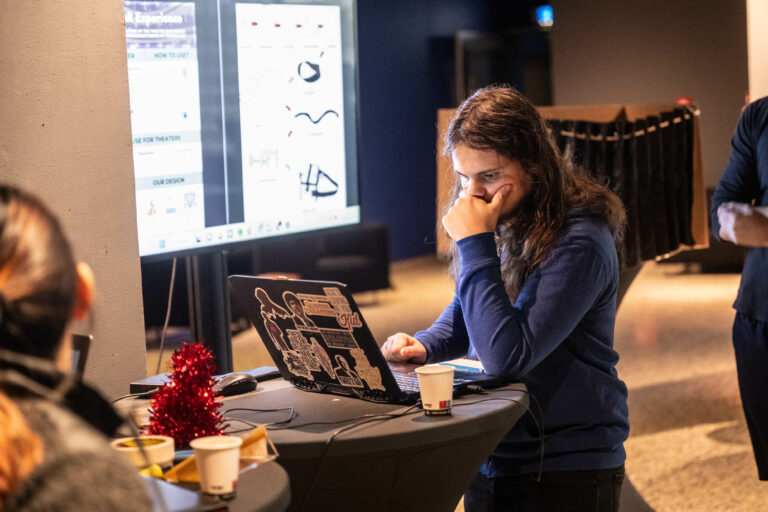 Deelnemer Crosswise achter laptop in De Oosterpoort.