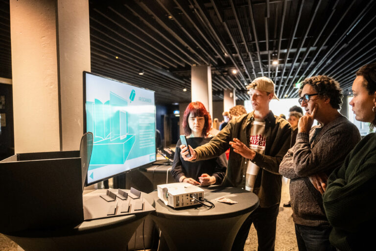 Deelnemers leggen concept uit met een groot scherm.