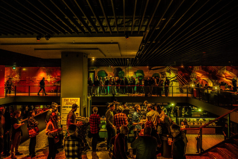 TakeRoot 2022 - Foyer Kleine Zaal, overal mensen op de foto. In de rij voor eten, in de rij voor artiest in bovenzaal.