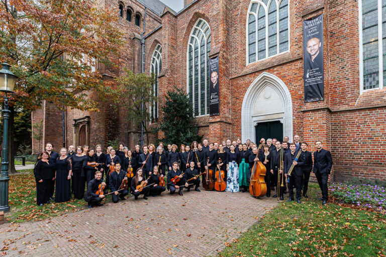 Luthers bach ensemble buiten met instrument in de hand voor de martini kerk.