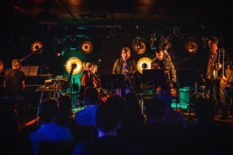 Een muzikale optreden in een sfeervolle locatie met meerdere musici op het podium.
