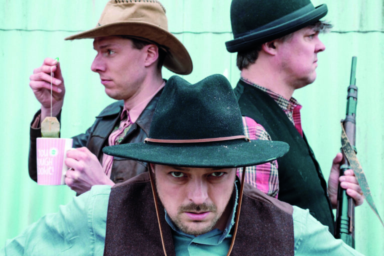 Drie mannen met cowboy kleding aan