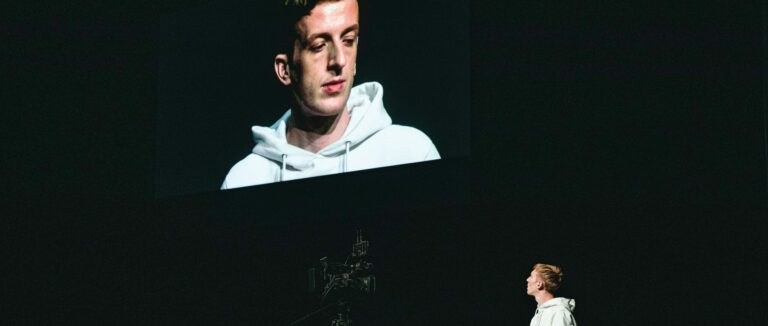 Man kijkt naar zichzelf op een groot scherm