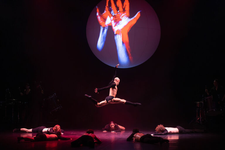 Danser springt onder grote bol