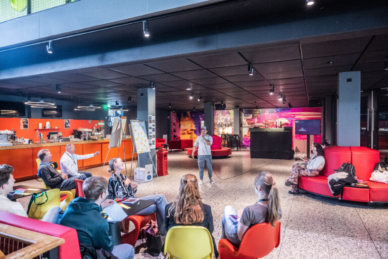 Deelnemers van de Hackathon zittend in het foyer middengebied van De Oosterpoort