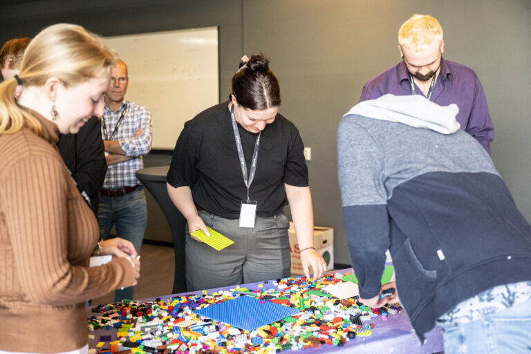 Deelnemers hackathon bouwen met lego onderdelen voor De Nieuwe Poort.