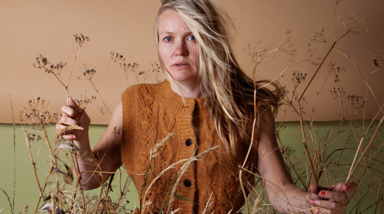 Vrouw zit tussen grassprieten