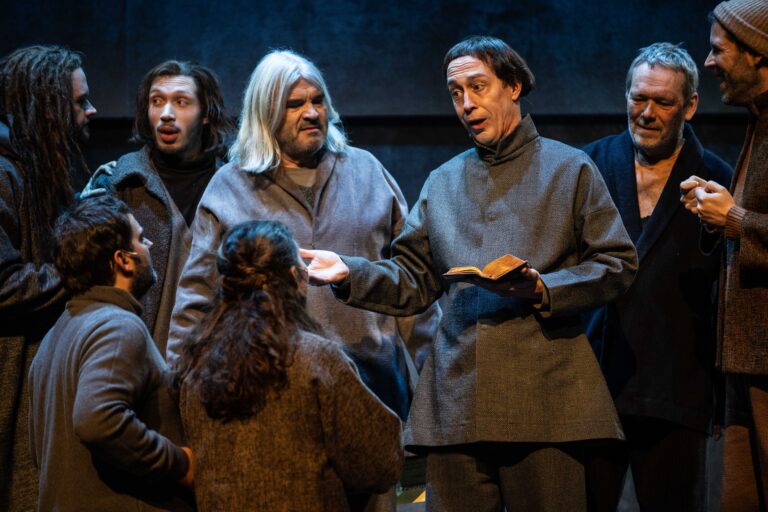 In bruin geklede mannen op een podium.