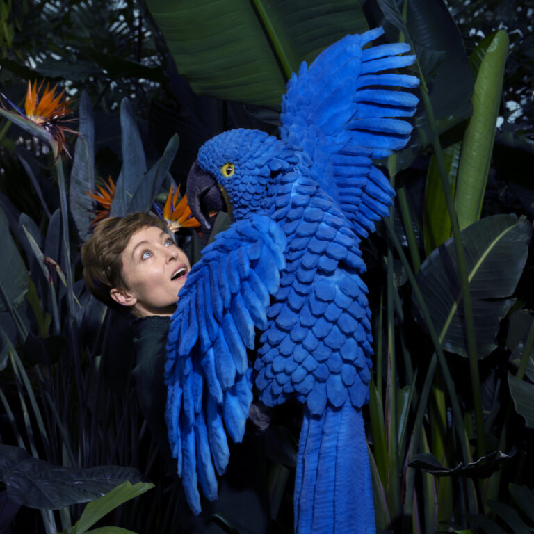 Acteur met blauwe vogel in het oerwoud
