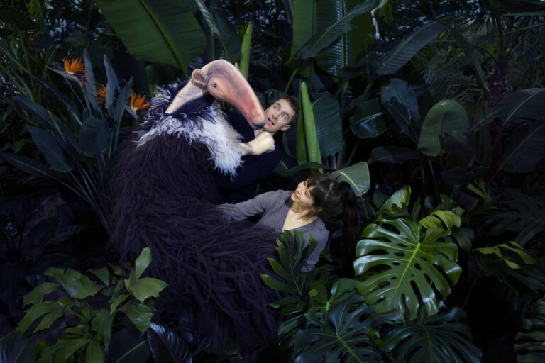 Twee acteurs met grote miereneter pop in de jungle