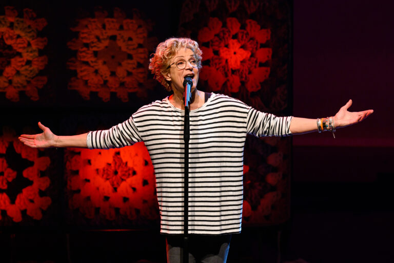 Lenette van Dongen in een gestreept shirt met haar armen gespreid
