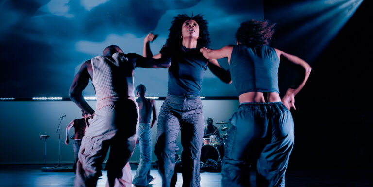 Drie dansers houden elkaar vast