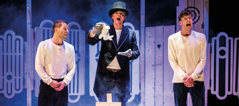 3 acteurs op het podium, eentje is goochelaar en haalt een konijn uit zijn hoed