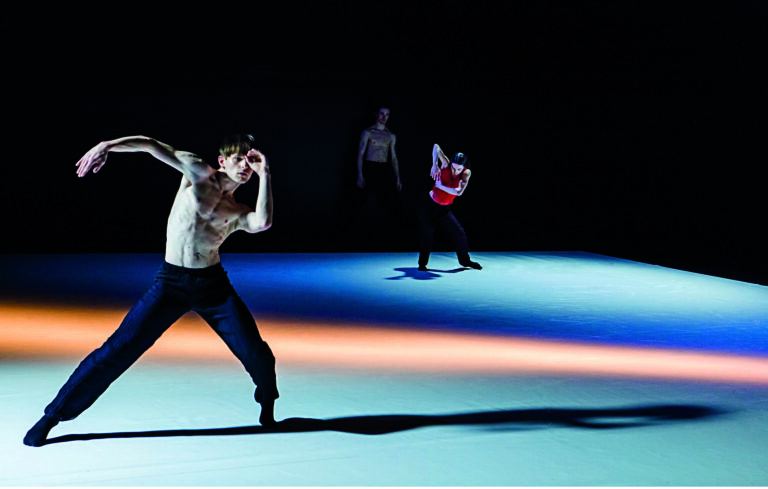 Drie dansers dansen op een kleurrijke vloer