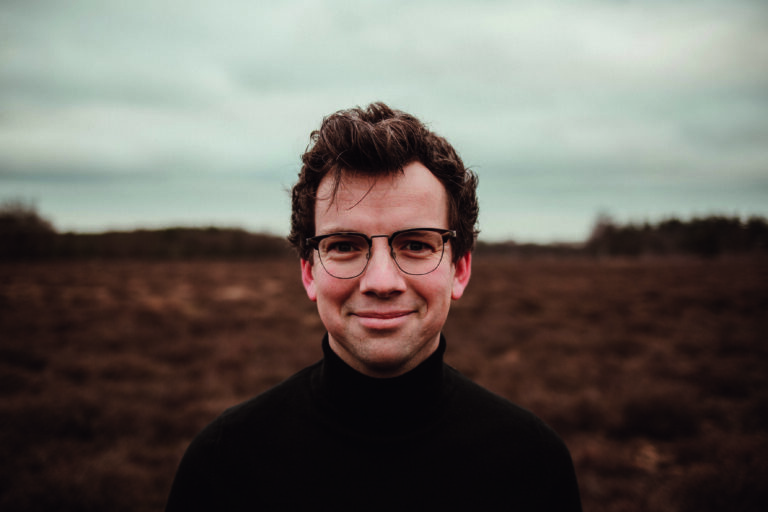 Portretfoto van Pieter Derks buiten met een bril op