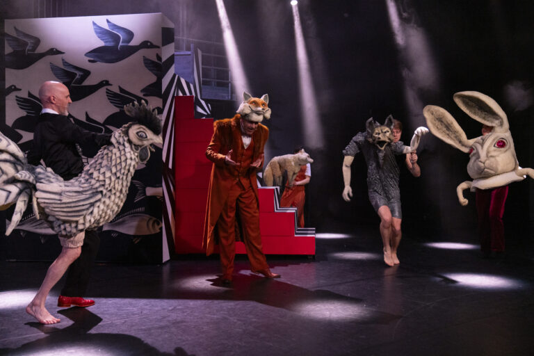 Acteurs in verschillende dierenkostuums op het podium.