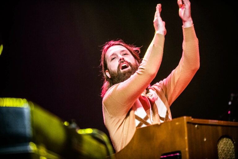 Een muzikant speelt enthousiast op een keyboard tijdens een live optreden.