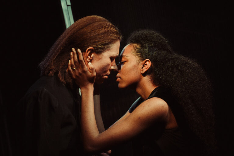 Twee mensen staan dicht bij elkaar en zijn met elkaar verbonden in een intieme pose.