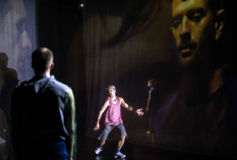 Danser in roze hemd staat voor projectie