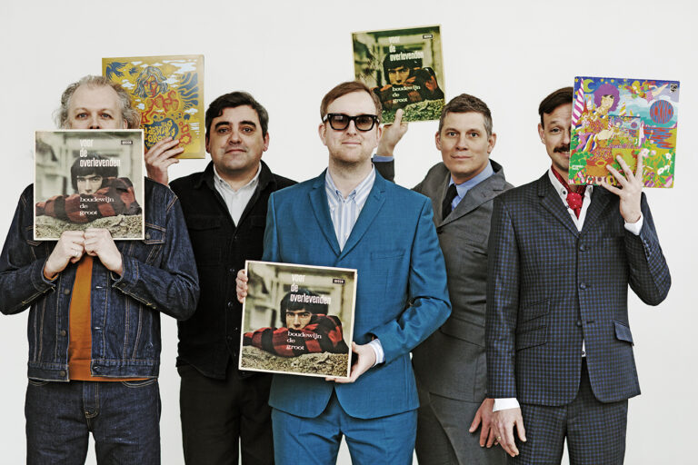 De vijf bandladen van The Kik staan op een rijtje naast elkaar met ieder een andere LP-hoes van Boudewijn de Groot in een hand.