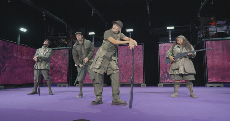 Acteurs in legerkleding leunen op (nep) geweer