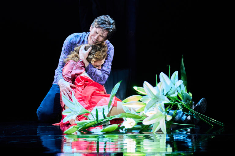 scènefoto vanMan huilt en heeft vrouw in rode kleding vast