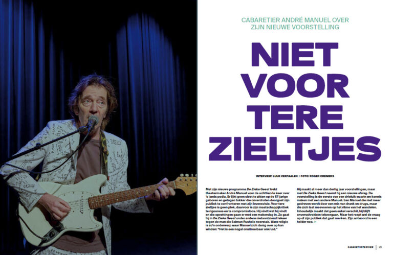 Een muzikant met een gitaar staat op het podium in een theater, met een blauwe achtergrond en tekst rechts van hem.