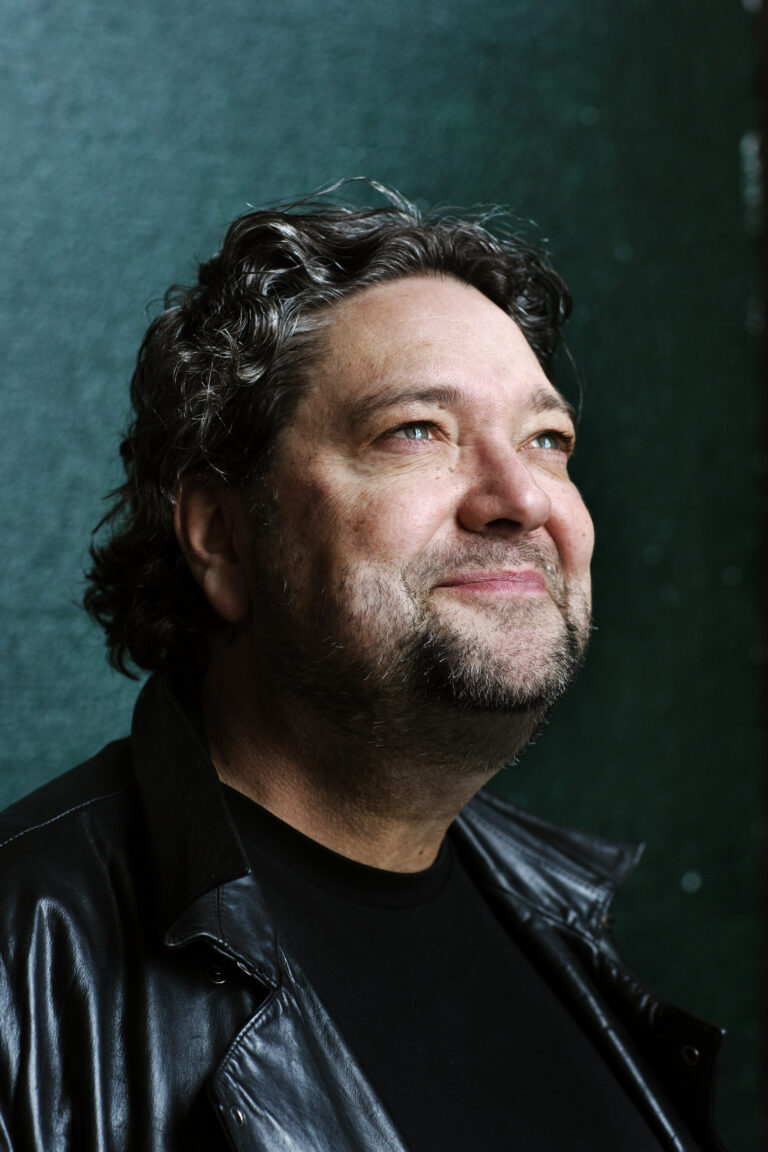 Mike Boddé kijkt naar rechts met donkergrijze achtergrond.