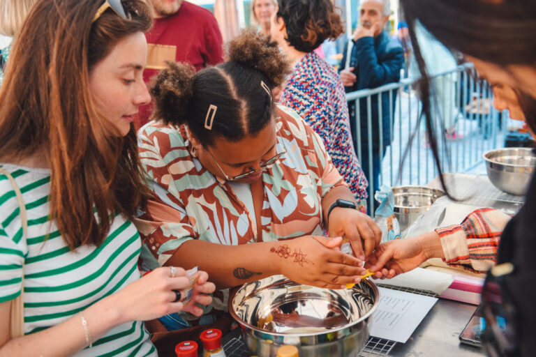 Vrouwen zijn bezig met het behalen van henna-tattoo's tijdens een buitenactiviteit.