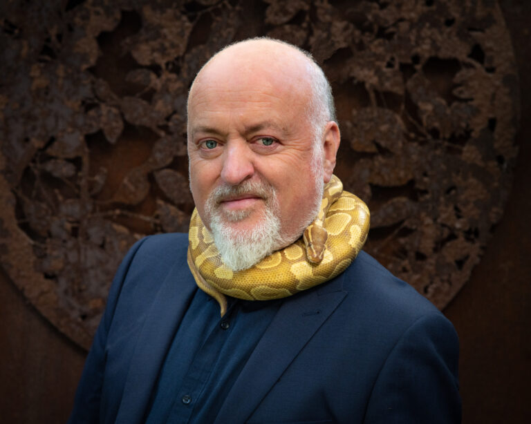 Bill Bailey met een gele slang om zijn nek