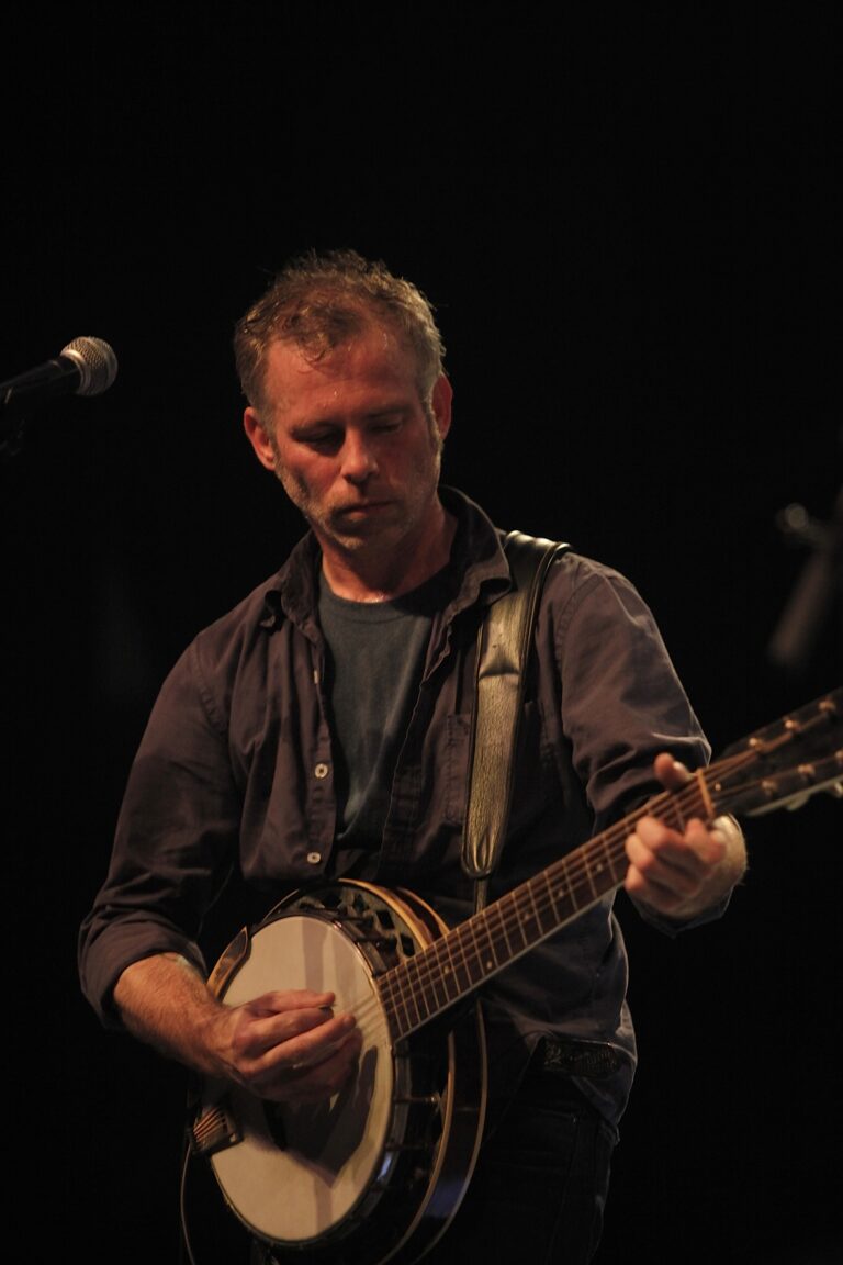 Een muzikant speelt op een banjo tijdens een optreden.