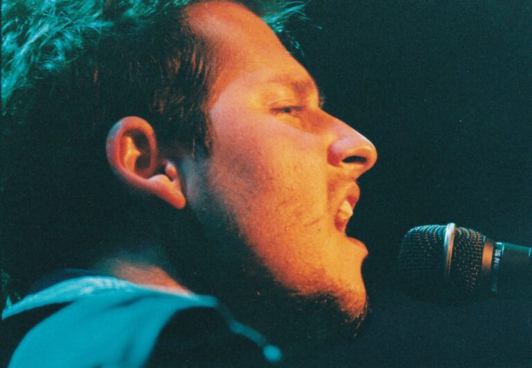 Close-up of a singer performing passionately into a microphone.