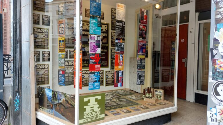 Etalage van Plato gevuld met TakeRoot posters van de afgelopen jaren