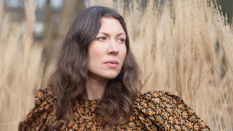 Een portretfoto van Alele Diane voor een veld met riet.